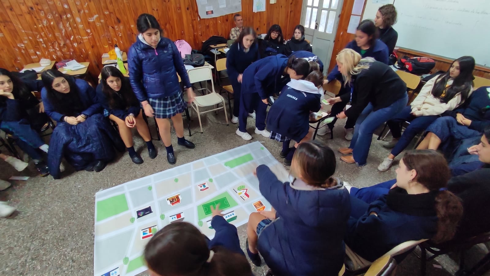 Estudiantes trabajando en ronda alrededor de un mapa durante un taller de prevención