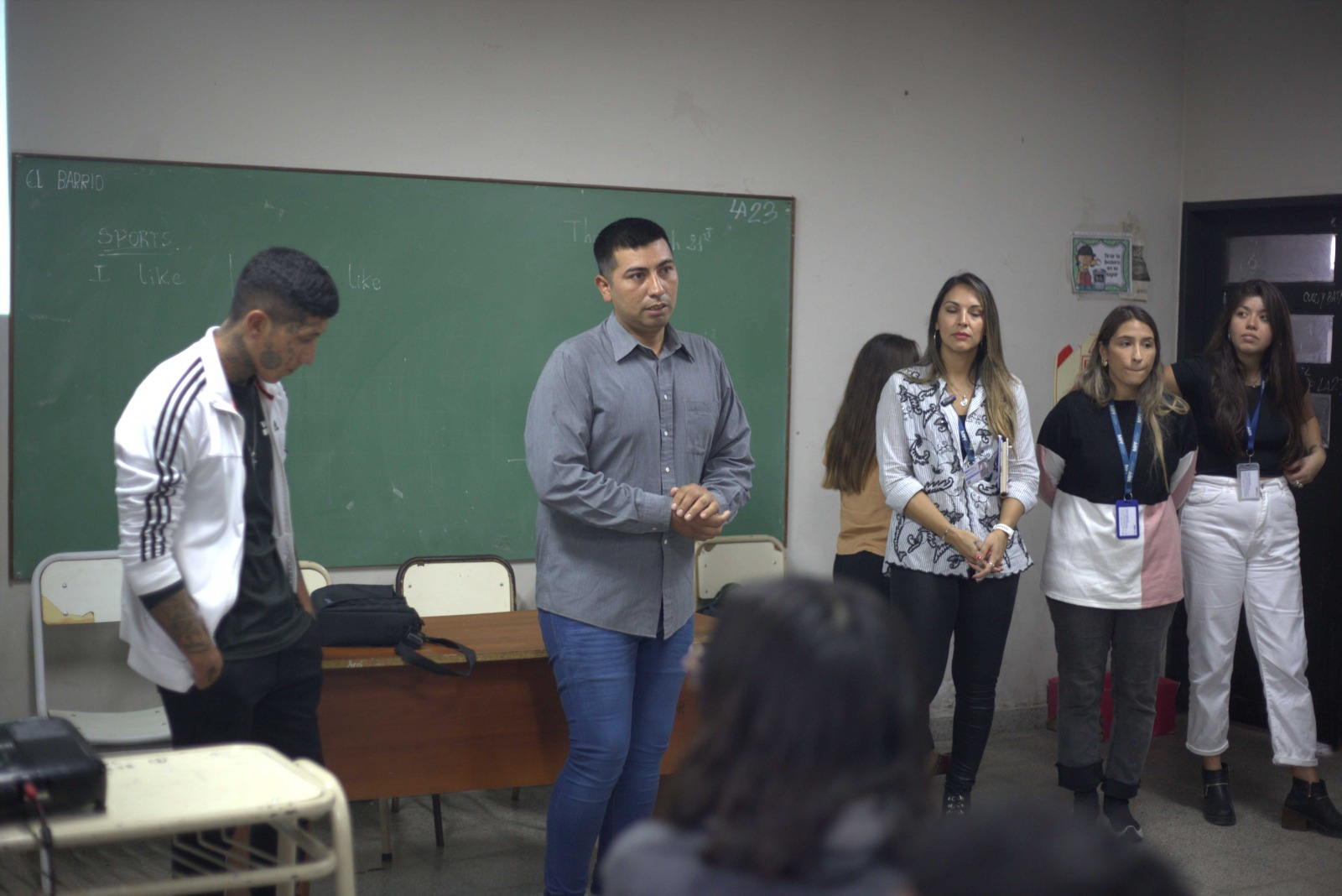 Coordinador junto a un joven presentando el taller frente a docentes y directivos