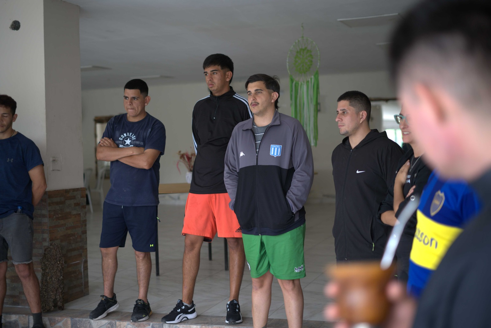 Jóvenes de pie escuchando durante un encuentro en la Fundación Elijo Vivir